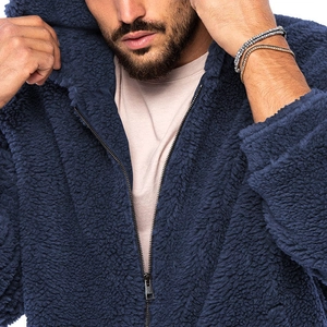 Nahaufnahme des dunkelblauen Sherpa-Fleece-Stoffs einer Herren-Winterjacke mit Kapuze