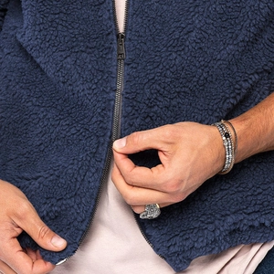 Detail der navyblauen Fleece-Struktur und des Bronze-Reißverschlusses der Winterjacke