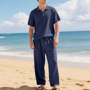 Heren set van marineblauw linnen shirt en broek tegen een zonnige strandachtergrond