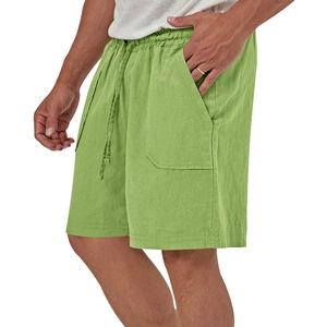 Dettaglio dei pantaloncini in lino verde con vita elastica a coulisse e ampie tasche laterali