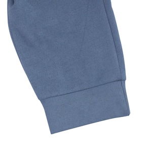 Dettaglio del polsino a costine e cuciture fini su un completo polo in maglia azzurra