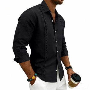 Detailed view of black linen shirt featuring vertical hollow embroidery and contrast buttons