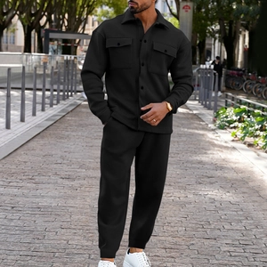 Detail of black button-up suede jacket with dual chest pockets and matching pants