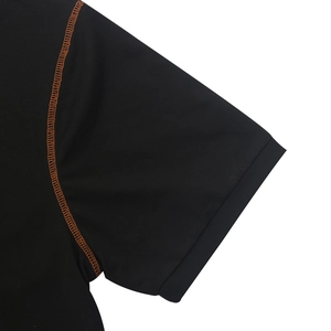 Détail du t-shirt Henley noir avec coutures contrastées orange et tissu respirant