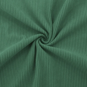 Detail shot of forest green ribbed corduroy fabric texture with soft folded layers