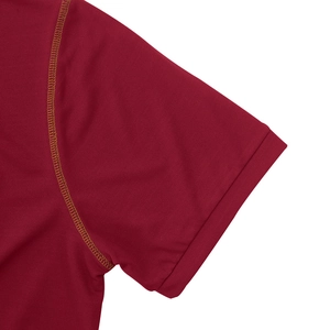 Détail du polo bordeaux avec coutures contrastées dorées et tissu en maille respirant