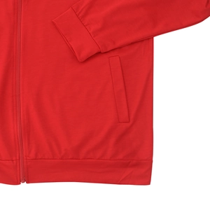 Detail of red bomber jacket featuring zip closure, ribbed cuffs and vertical side pockets