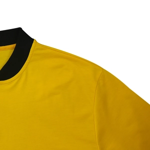 Detail of a bright yellow bomber jacket showing black ribbed collar and precise stitching