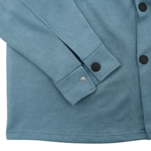 Detailed macro view of teal faux suede jacket sleeve with matte button and fine stitching