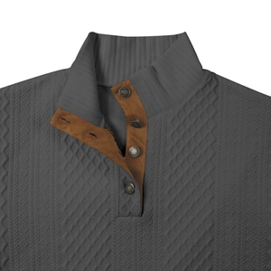 Detalle de suéter gris oscuro con textura jacquard 3D y ribete de ante marrón