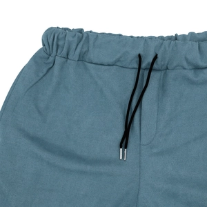 Detail view of blue faux suede shorts featuring elastic waistband and black drawstrings