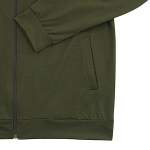 Detailed close-up of olive green bomber jacket featuring ribbed cuff and zipper pockets