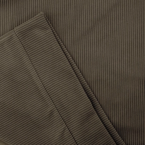Detail of dark olive brown corduroy fabric with vertical ribs and fine stitching on the hem