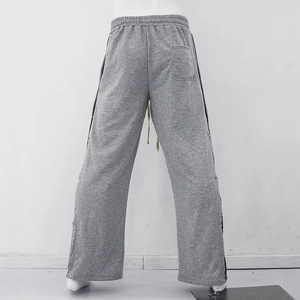 Détail du jogging gris avec taille ajustable à cordon et boutons-pression latéraux