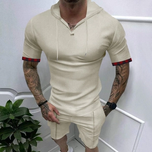 Dettaglio del tessuto waffle e bordo scozzese rosso sul set beige da uomo con cappuccio
