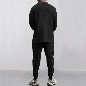 Detail der Herren-Strickkombi mit Zopfmuster in Schwarz, Langarmhemd und Hose