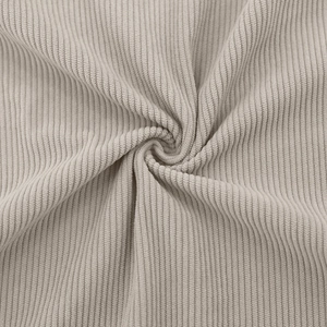 Detailed macro view of the soft beige corduroy fabric texture and vertical ribbed pattern