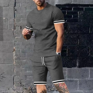 Detalle de conjunto deportivo gris oscuro para hombre con puños de canalé a rayas