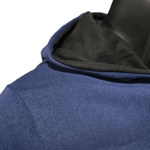 Detail of blue thermal hoodie with knitted texture and black ribbed lining on the hood