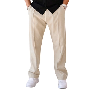 Close-up of beige casual pants featuring a drawstring waistband and vertical pleated details