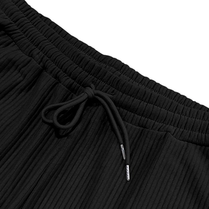 Detalle de pantalón de pana negra para hombre con cintura elástica y cordones