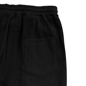 Detalle de pantalón de pana con cintura elástica y diseño de bolsillo trasero plano
