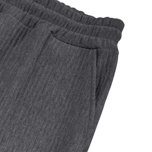 Detalle de pantalón de pana gris oscuro con cintura elástica y textura del bolsillo