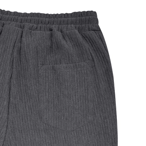 Detalle del pantalón de pana gris oscuro con cintura elástica y textura acanalada