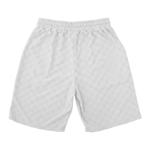 Detail view of white men's casual shorts showing 3D checkered waffle texture and elastic waist