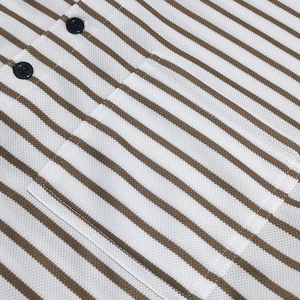 Detail of piqué cotton striped shirt showing the chest pocket and black buttons
