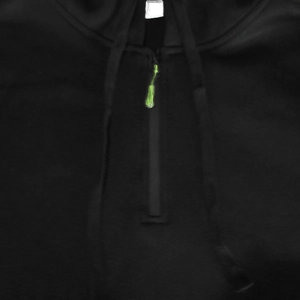 Detail of black pullover hoodie featuring a half-zip and vibrant green zipper puller