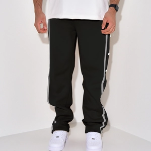 Detail of men's black casual trousers with side white stripes and metal buttons