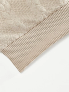Detalle del acolchado jacquard con diseño de hojas y puños acanalados del suéter