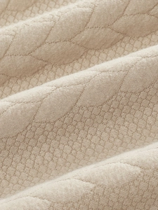Primer plano del tejido de punto beige con textura de diamantes 3D en jersey de hombre