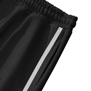 Detail view of elastic waistband and white side stripe on black casual straight pants