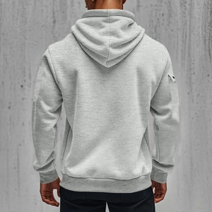 Back view detail of men's light grey hoodie showing utility sleeve pocket and ribbed hem