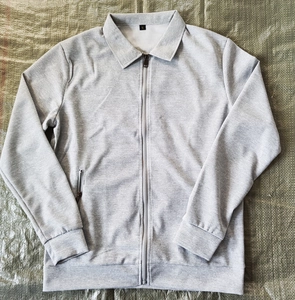 Detail of grey men's waffle jacket showing front zipper, collar and textured fabric