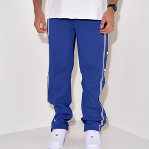 Detail view of men's blue trousers featuring grey side stripes and white snap buttons
