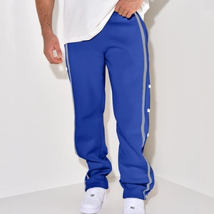 Detail view of men's casual blue pants featuring white side buttons and reflective grey stripes