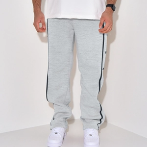 Detail of grey men's sweatpants featuring black side stripes and metal snap buttons