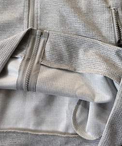 Detailed macro shot of light grey waffle texture fabric and high-quality zipper work