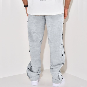Detail view showing black snap buttons on the side of grey casual men's trousers