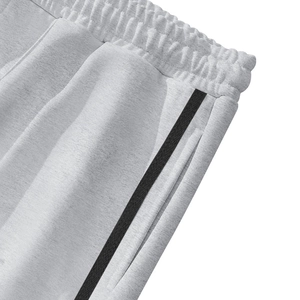 Detail of light gray fleece sweatpants featuring elastic waist and side stripes