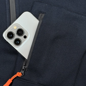 Detail of navy hoodie showing a black nylon zipper pocket with orange puller and phone space