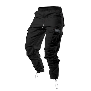 Détail du pantalon cargo noir montrant des poches multiples et l'ourlet à cordon ajustable