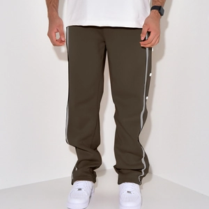 Detail of olive green pants featuring side stripe tape and functional snap buttons