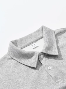 Detail of grey polo shirt collar with M size wash label and two white buttons