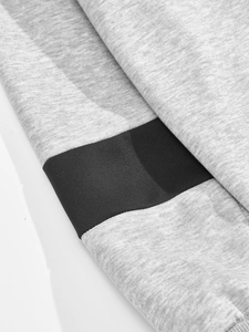 Detailed close-up of grey knitted fabric with black horizontal拼接 contrast panel