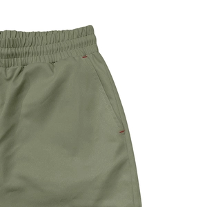 Détail du pantalon cargo olive avec taille élastique et coutures de renfort rouges