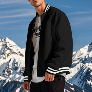 Detail of black varsity jacket with striped ribbed collar and cuffs against a snowy background
